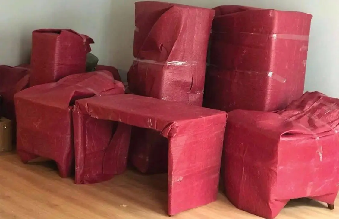 Florya nakliyat: kırmızı koruyucuyla paketlenmiş masa ve koltuklar